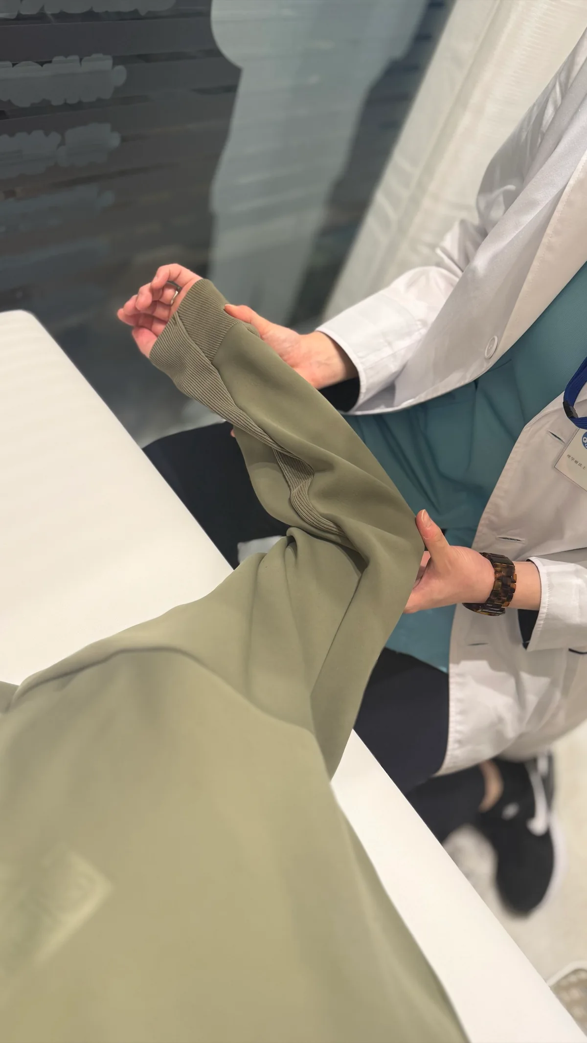 腕を支えながら肩の動きを確認する理学療法士